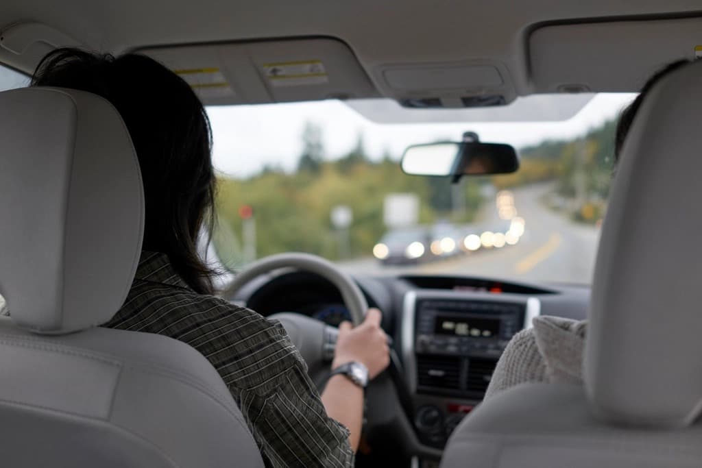 New driver at the wheel with a passenger on a two-lane road