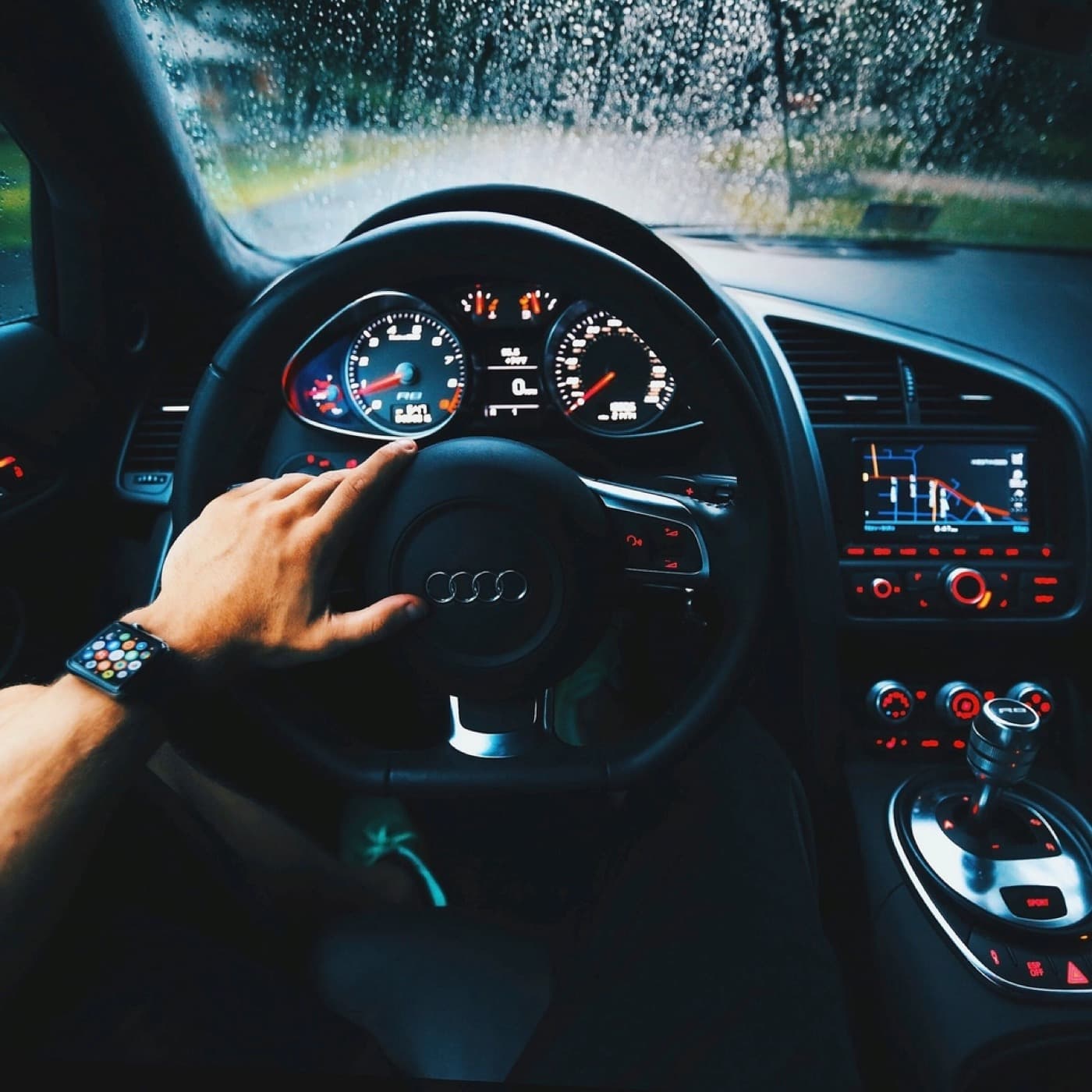 Driver holding paperwork at the wheel of a parked car