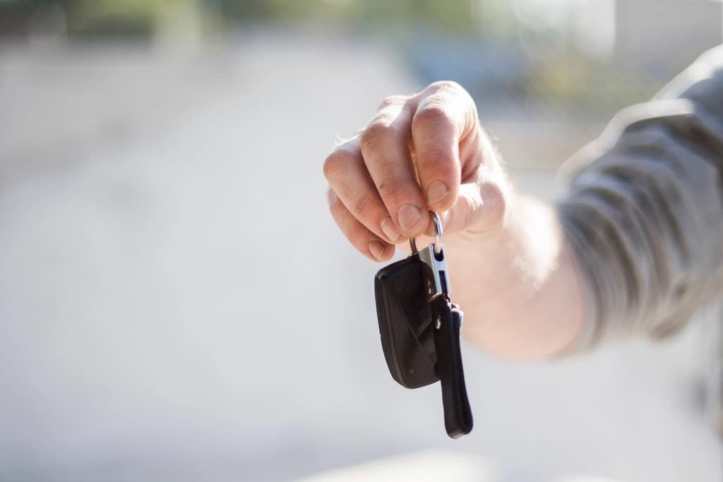 Driver holding out a car key